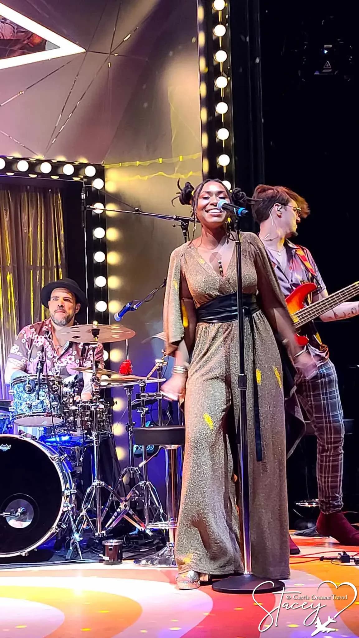 A singer and live band performing on stage aboard a Virgin Voyages ship