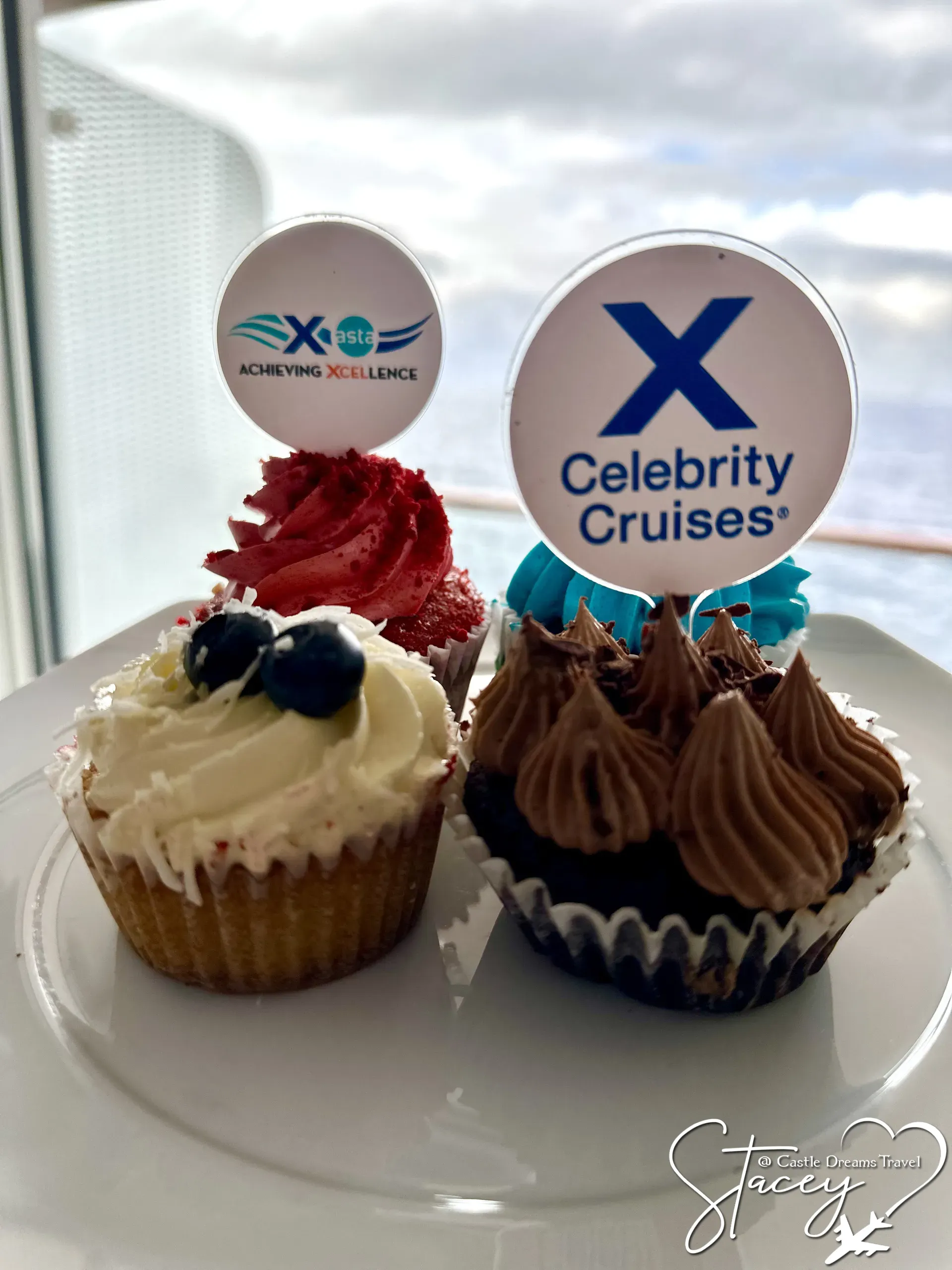 Celebrity Cruises branded cupcakes topped with the line's X logo on a white plate