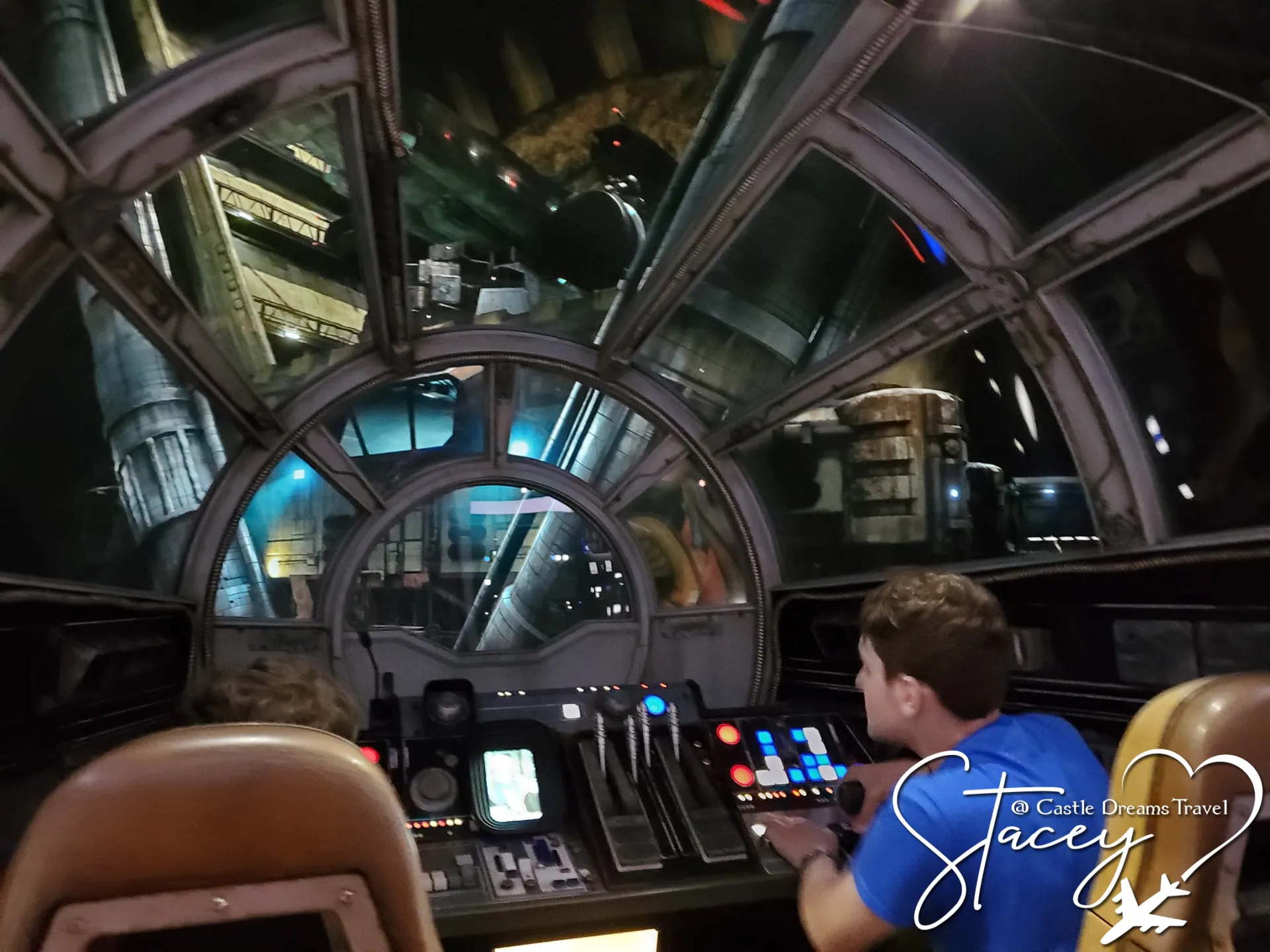 Two boys at the controls in the cockpit of the Millennium Falcon at Star Wars: Galaxy's Edge