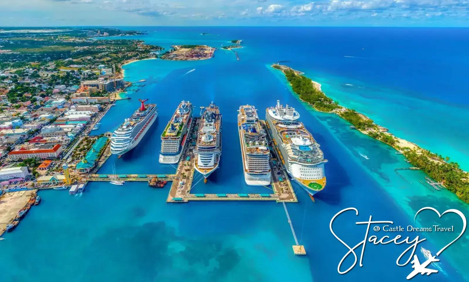Aerial view of five cruise ships docked at a turquoise island port