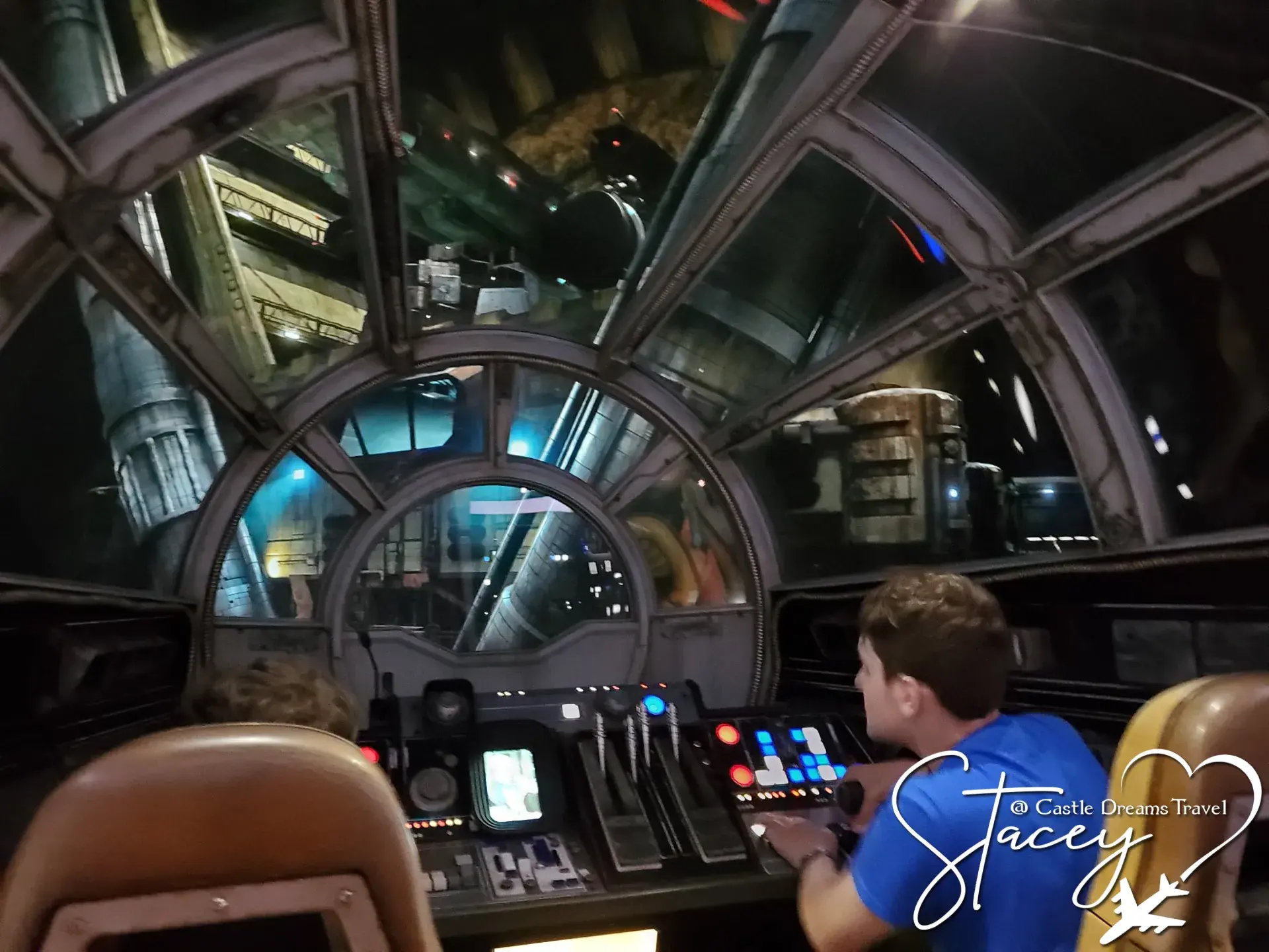 Two boys at the controls in the cockpit of the Millennium Falcon at Star Wars: Galaxy's Edge