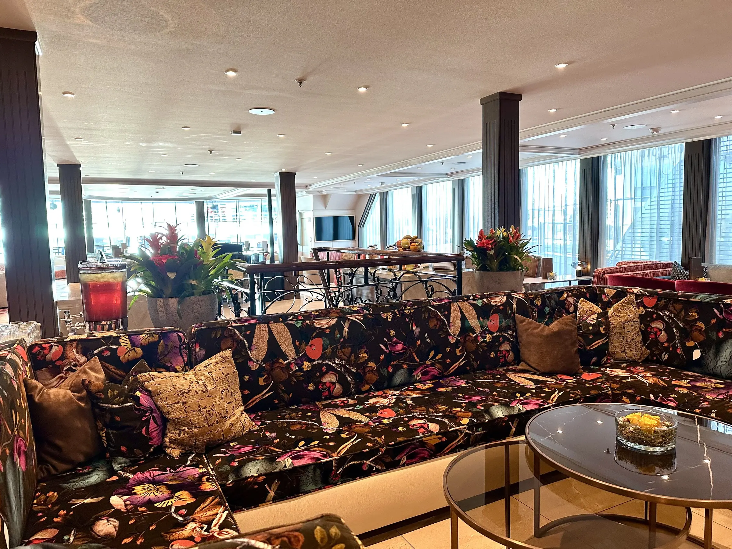 The main lounge aboard AmaWaterways' AmaMagna, floral upholstery and floor-to-ceiling river windows