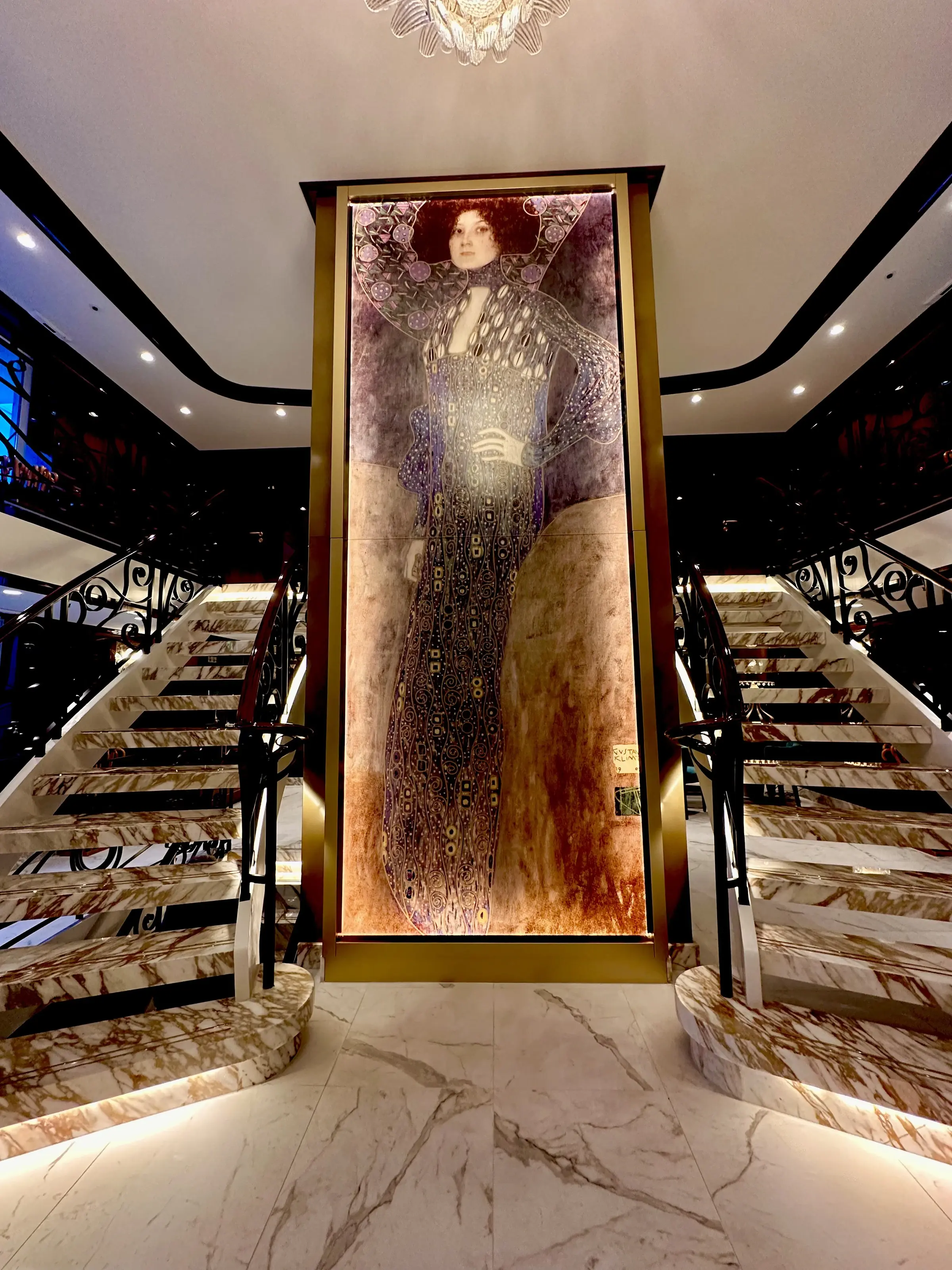 Uniworld's marble staircase framing a gilded Klimt-style portrait
