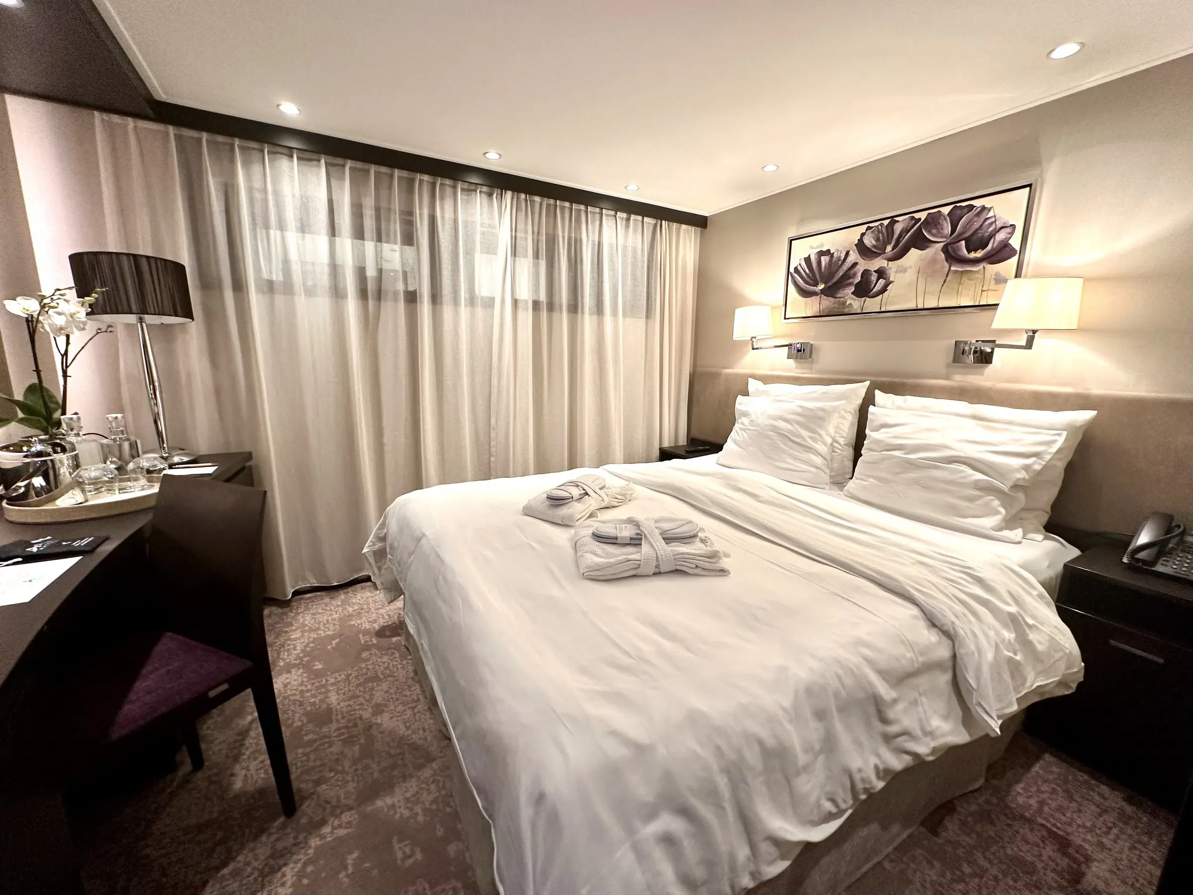 An Amadeus river ship stateroom with a wide bed and reading lamps