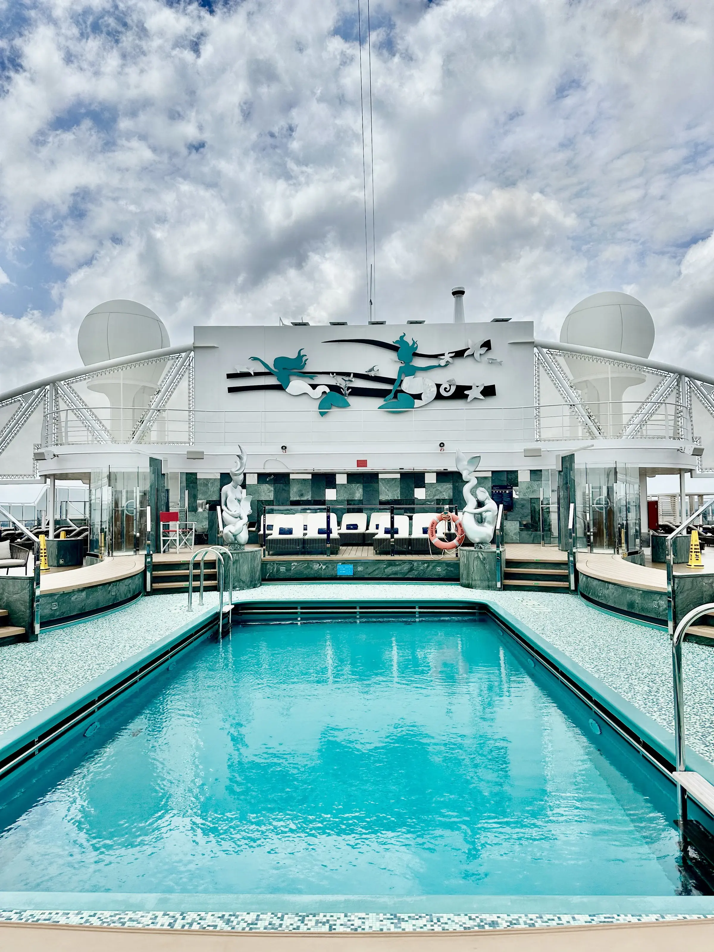 The private MSC Yacht Club pool deck, its own pool ringed by loungers