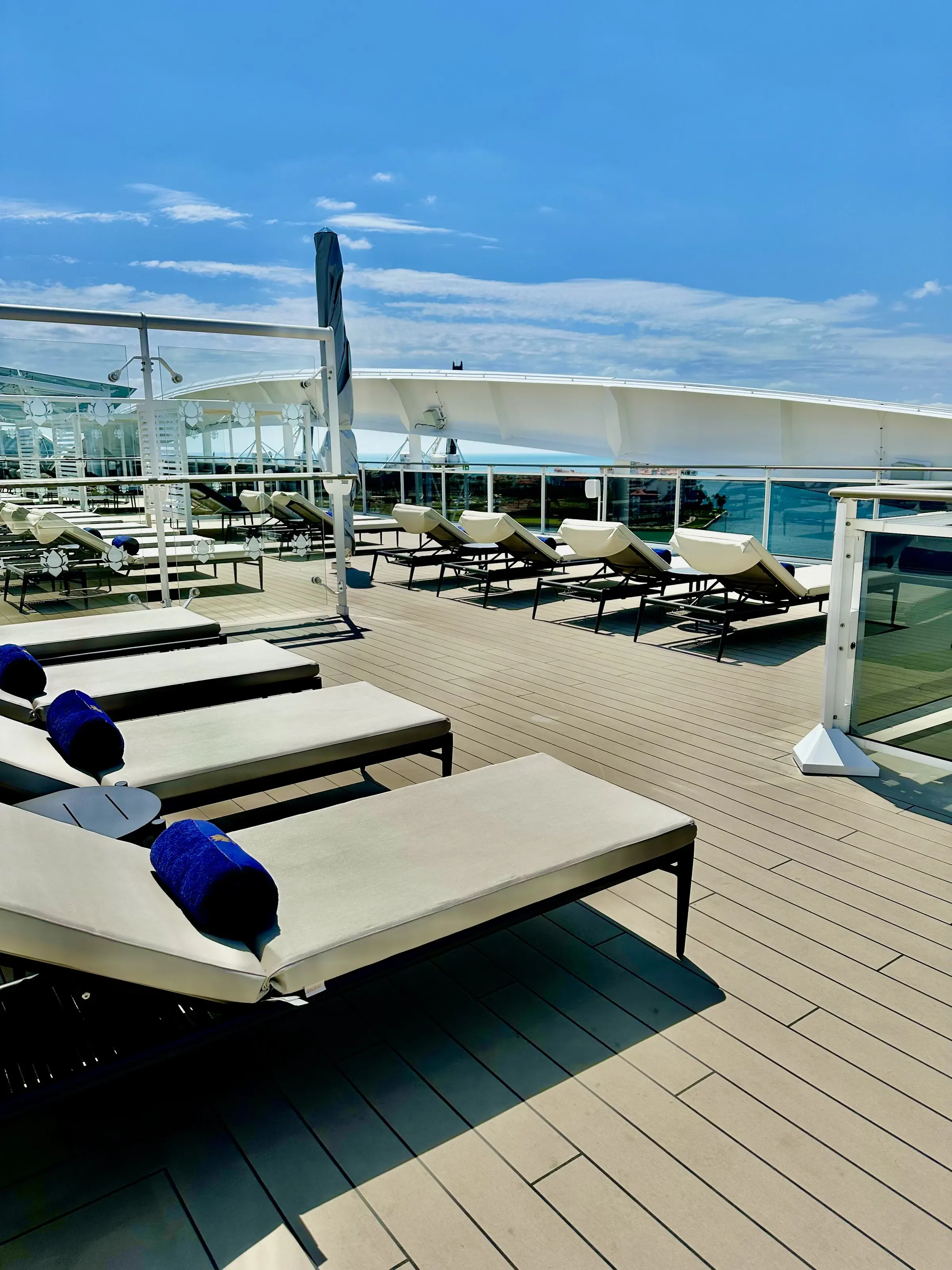 Cushioned loungers lined along the private MSC Yacht Club sun deck