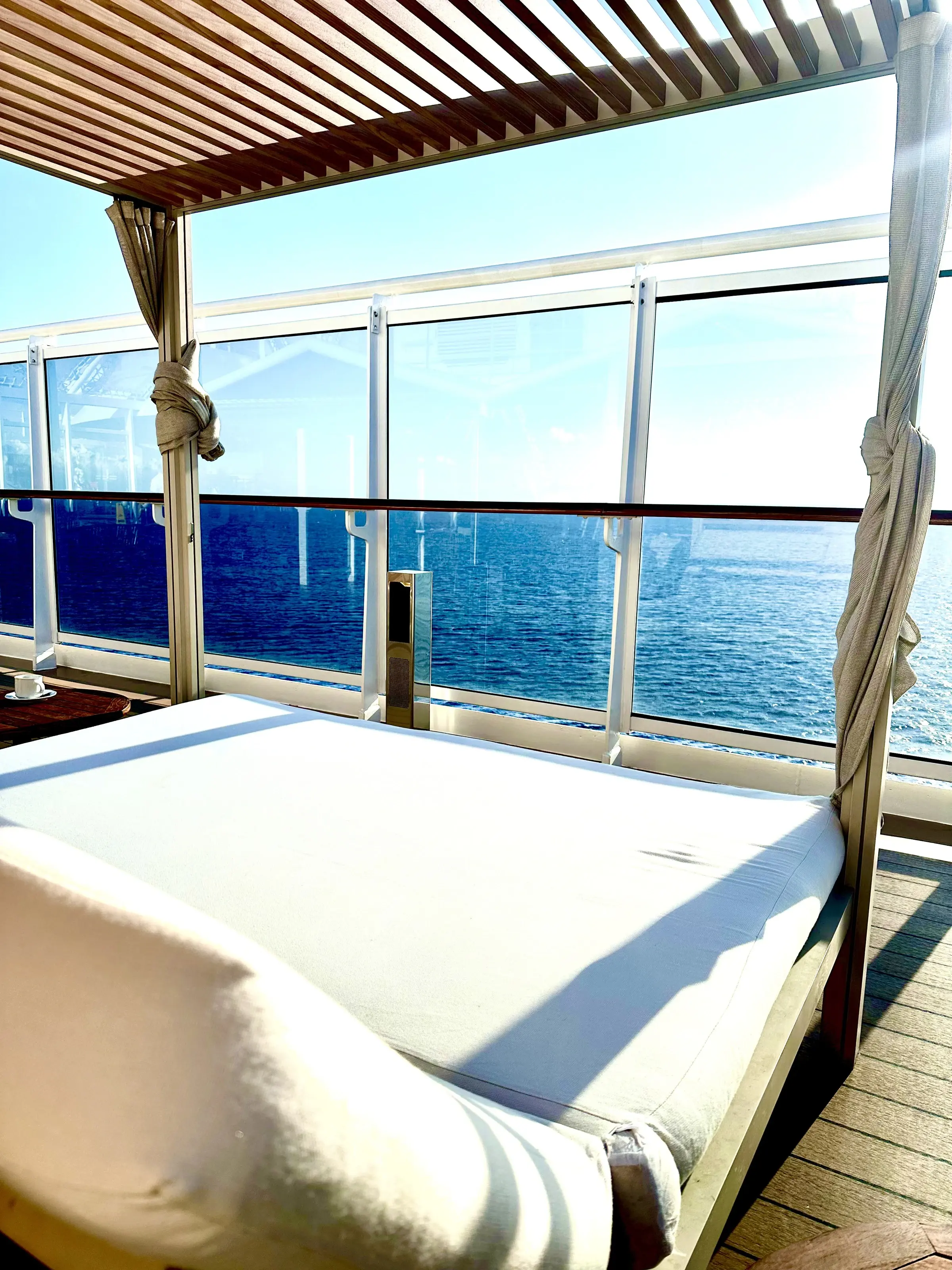 A curtained daybed on a private MSC balcony looking out over the ocean
