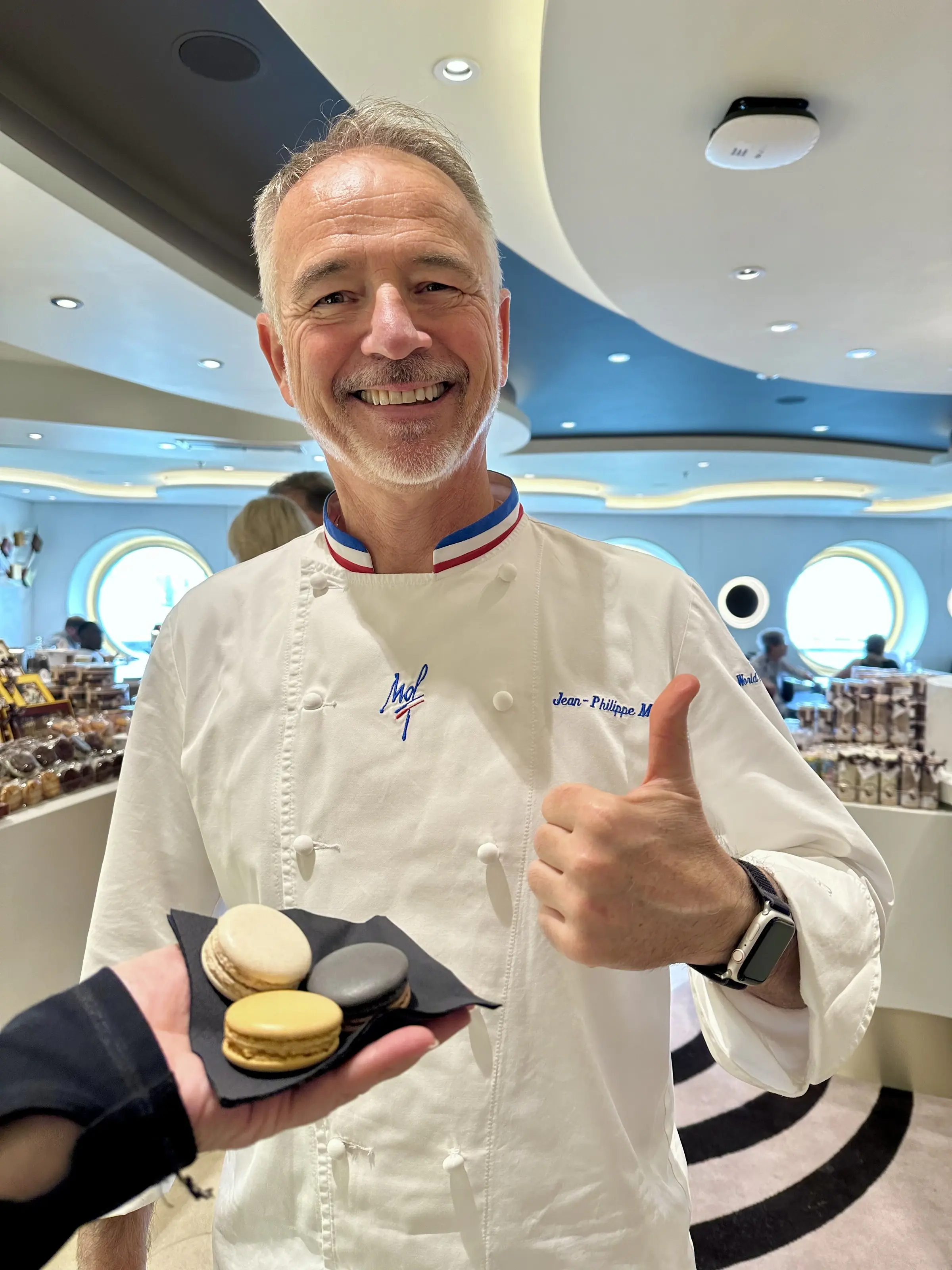 A pastry chef presenting a tray of macarons aboard an MSC ship