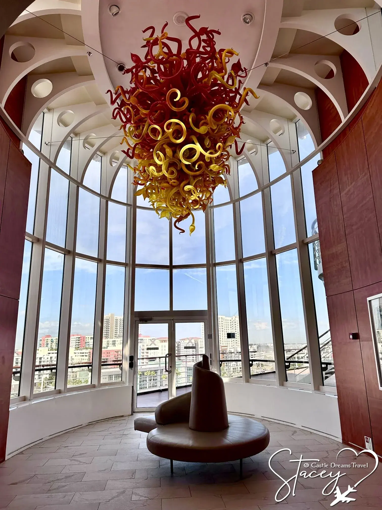 The Grand Plaza aboard a Celebrity ship beneath its red blown-glass chandelier